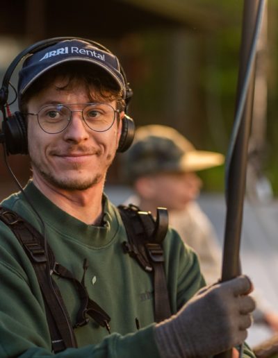 portrait of sound operator on movie set with boom microphone